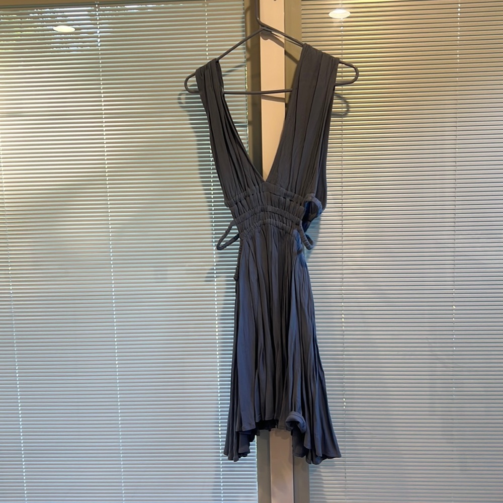 Powder blue dress cut low with cut out sides .